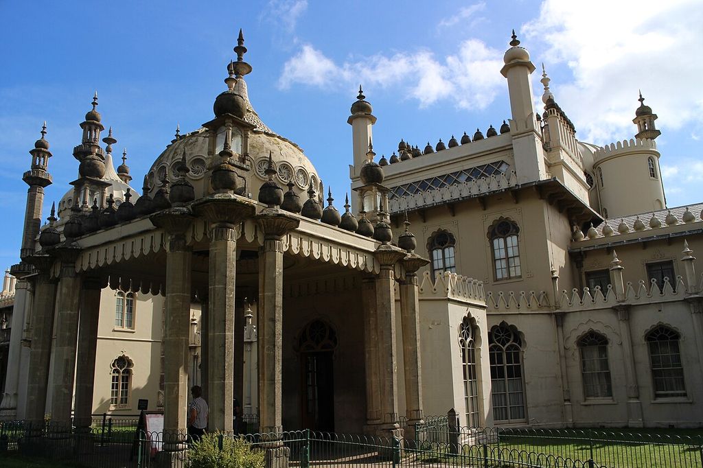 A cream palace exterior combines a large bulbous dome, slender minaret-like towers, pinnacles, tent-like roof edges and many differently shaped arched windows.