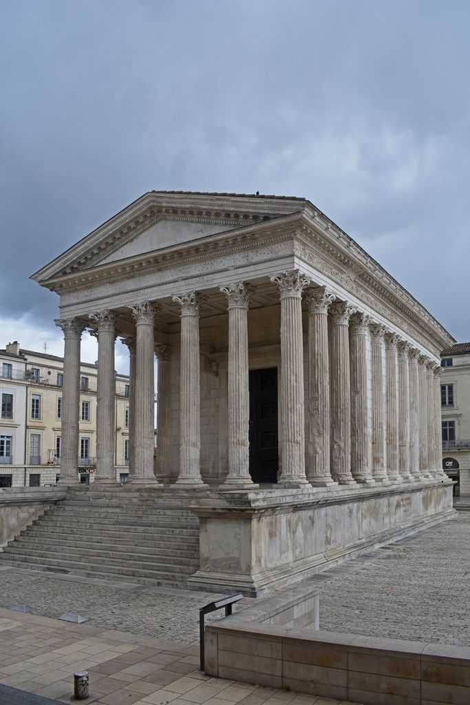 Fluted columns stand free across a temple porch and continue as curved projections against the long side wall.