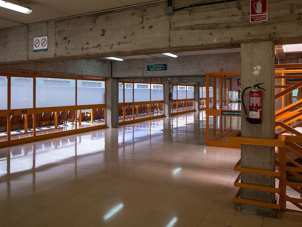 Square-edged concrete uprights meet deep horizontal beams above a glazed corridor.