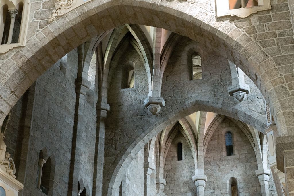 A massive round stone arch crosses the foreground while several narrower pointed arches overlap in the masonry behind it.