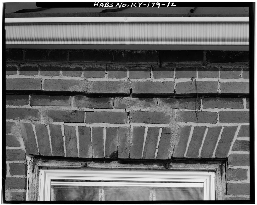 A black-and-white close-up shows tilted brick joints over a flat window head, with cracked mortar and a cornice above; the film border carries a HABS identifier.