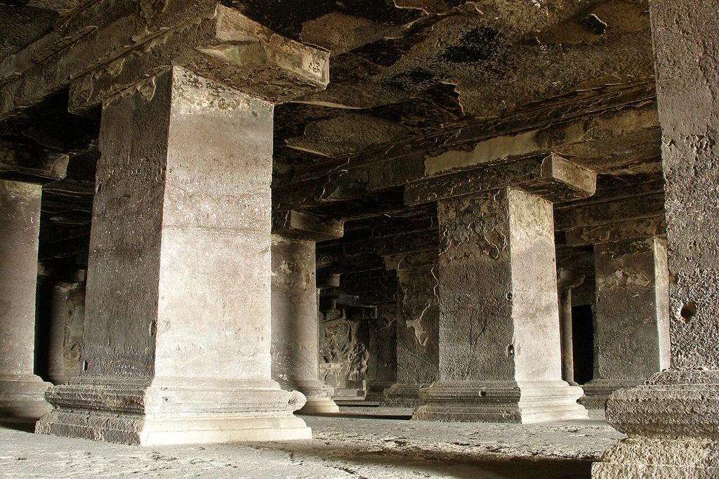 Square stone supports with moulded bases and broad capitals remain joined to the hall’s rock ceiling.