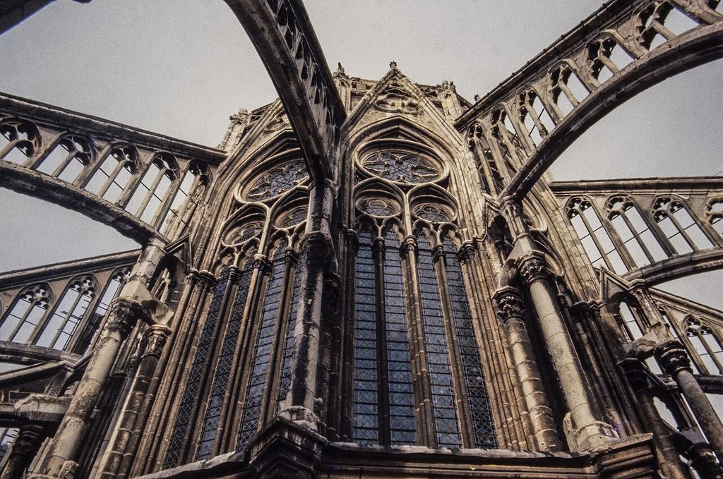 Pierced stone flyers cross above large tracery windows and meet the upper choir wall.
