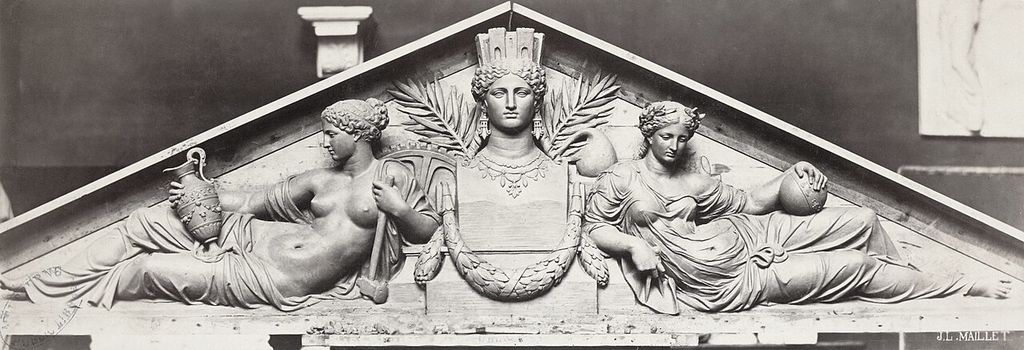 Bas-relief: Classical style figures inside a pediment: bust of a crowned female figure with reclining female figures on either side, one holding an amphora the other a globe.