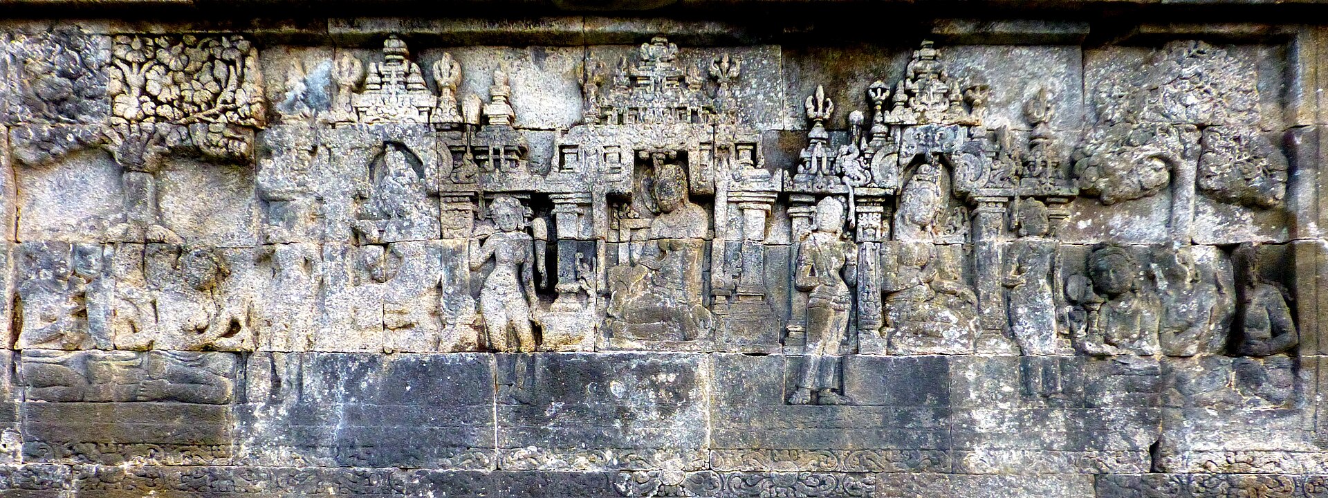 Lalitavistara relief with Queen Māyā shown within more than one palace setting, amid attendants and architectural framing.