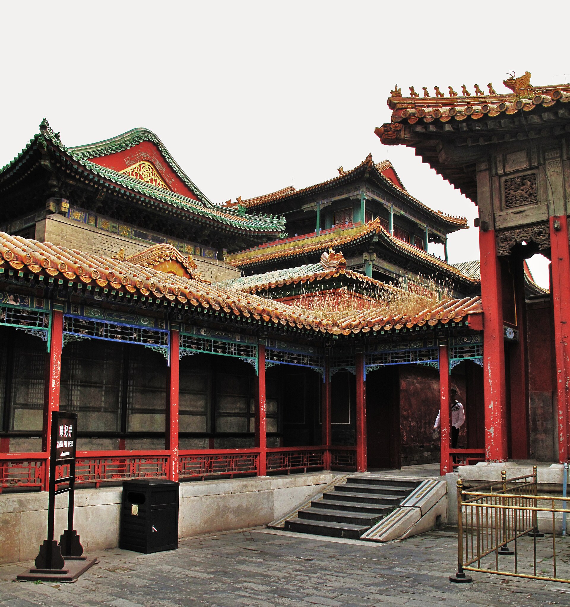 Small courtyard surrounded by red columns and roofs of yellow and green tile in the Qianlong retirement-garden precinct.