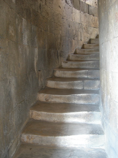 Worn stone spiral staircase rising within the wall of the Leaning Tower of Pisa.