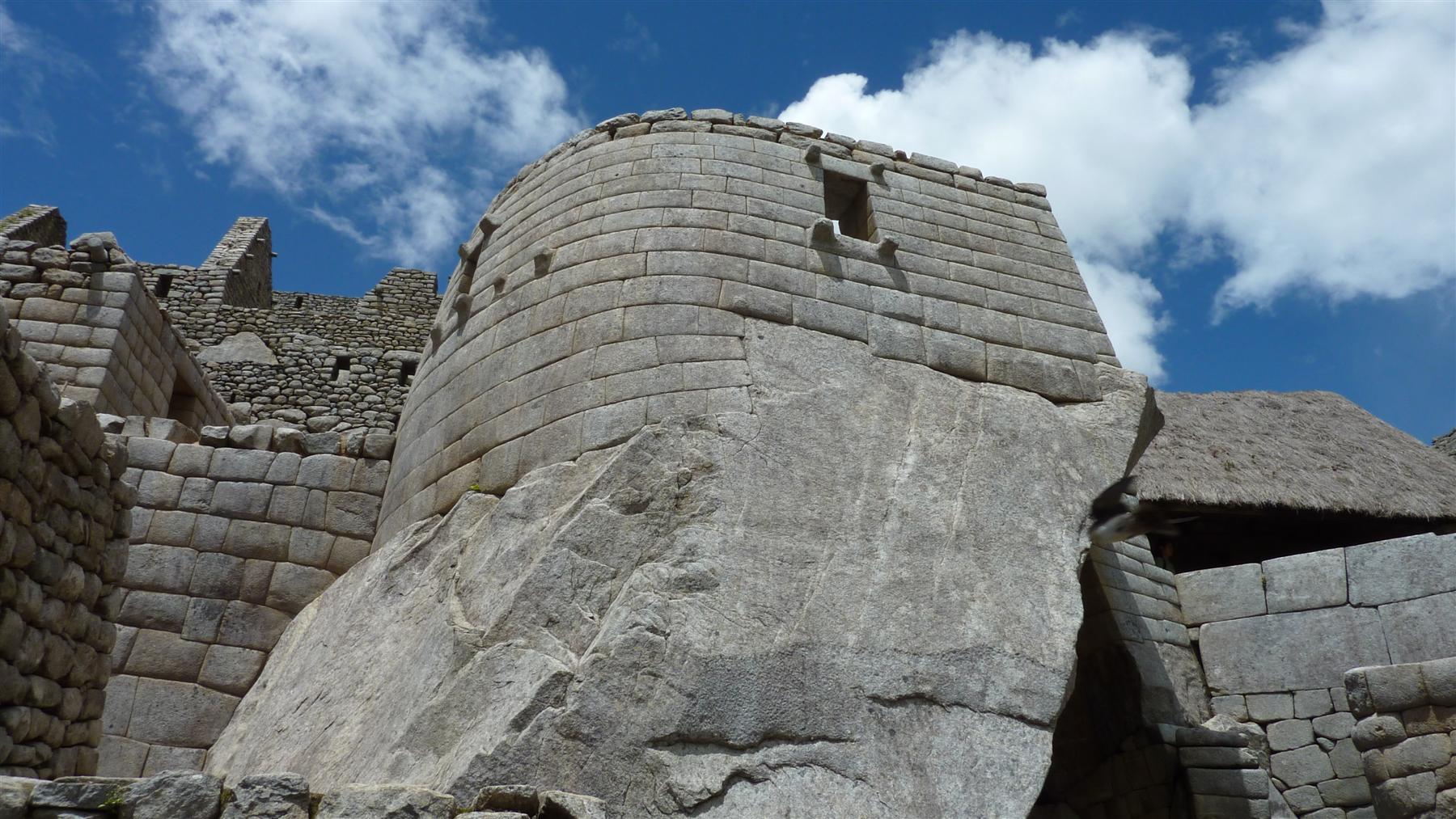 Semicircular finely fitted Torreón wall around a large granite outcrop, with a narrow upper window.
