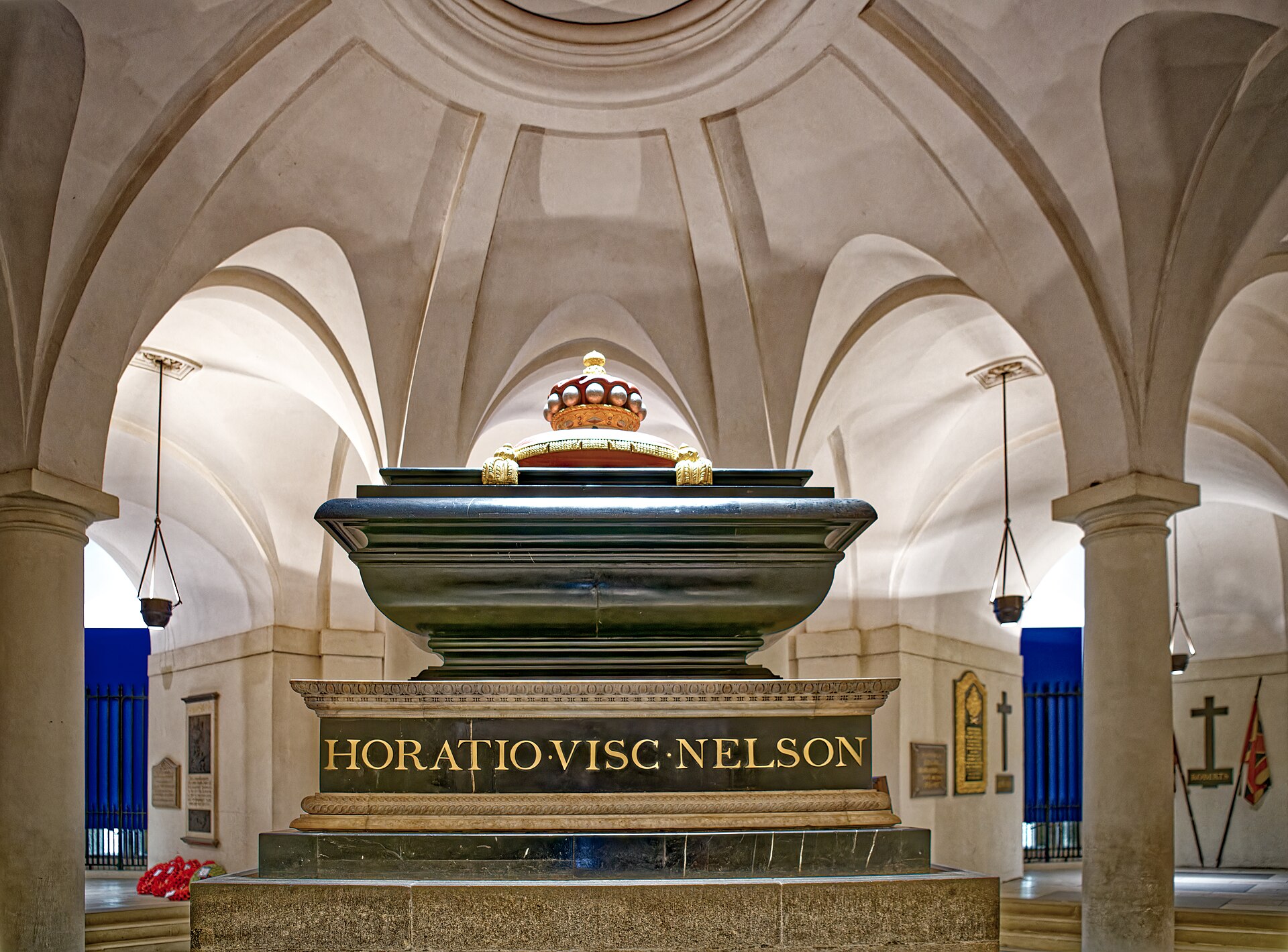 The dark stone sarcophagus of Admiral Nelson in the crypt of St Paul’s, enclosed by pale arches and an iron railing.