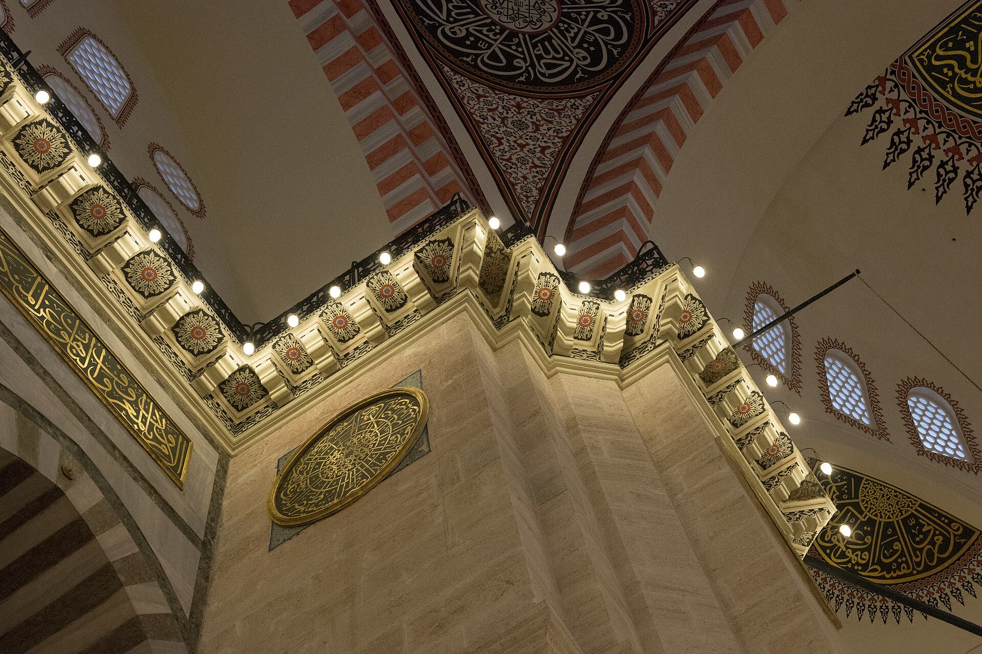 Low-angle view of a substantial interior support and load-bearing arch in Süleymaniye Mosque.