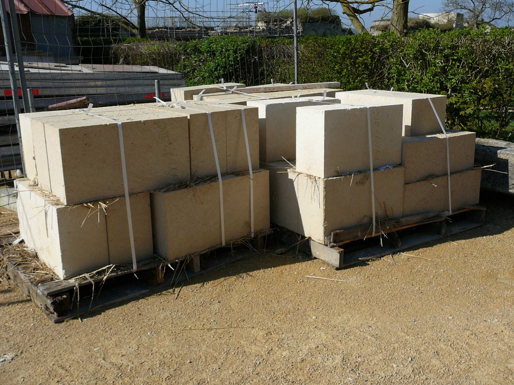 Pallets of rectangular quarry-cut stone strapped for transport, awaiting further dressing.