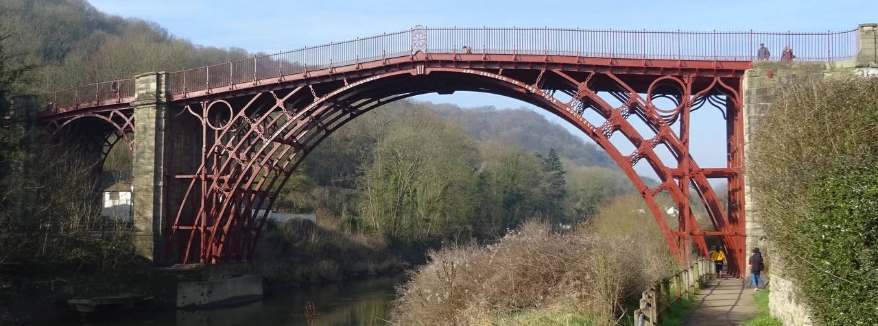 Red iron ribs and circular spandrels of the Iron Bridge over the Severn.