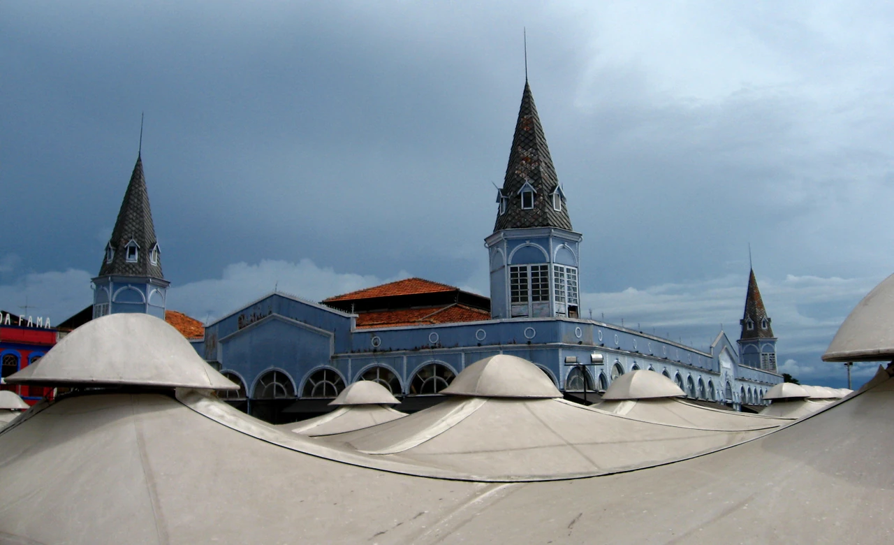Pointed corner towers of a blue-gray market building rise above rounded pale canopies in Belém’s Ver-o-Peso complex.