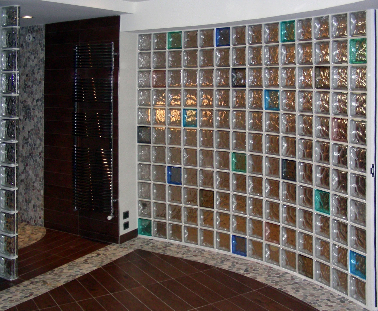 Textured glass blocks arranged in a curved interior partition, with a second wall at right.