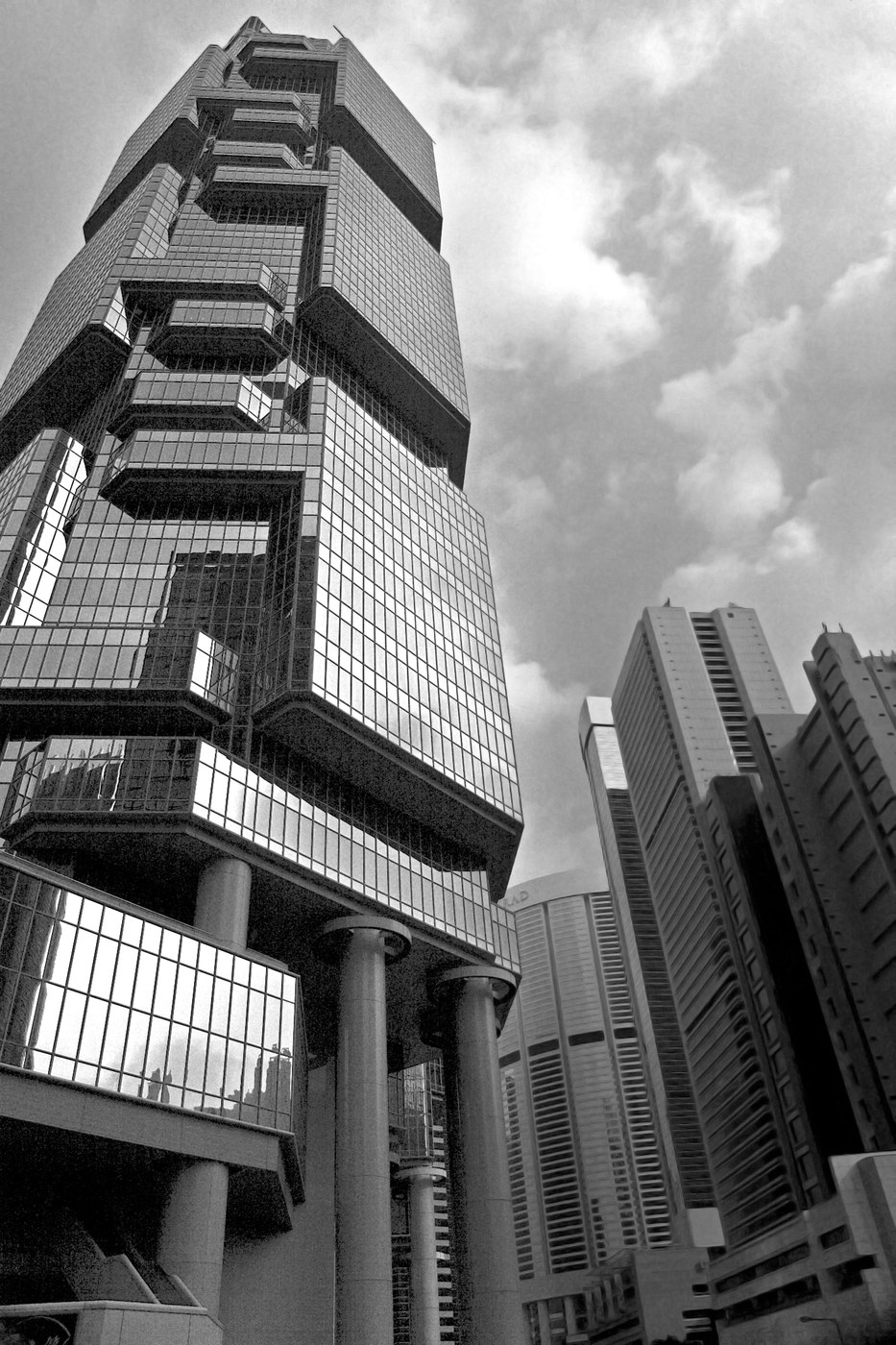 Low-angle black-and-white view of the Lippo Centre and neighbouring towers, showing reflective gridded cladding.