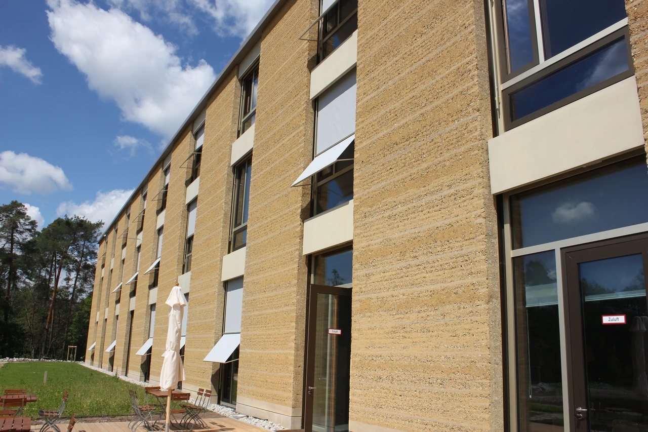 Alnatura Darmstadt facade with horizontally banded earth piers and tall strips of windows.