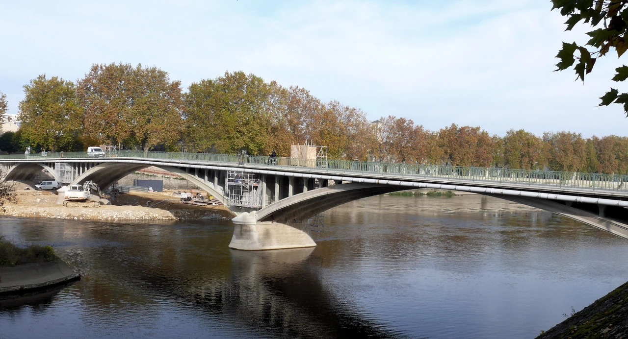 Low concrete arches support a road deck over the Vienne, with scaffolding and repair equipment visible beside the piers.