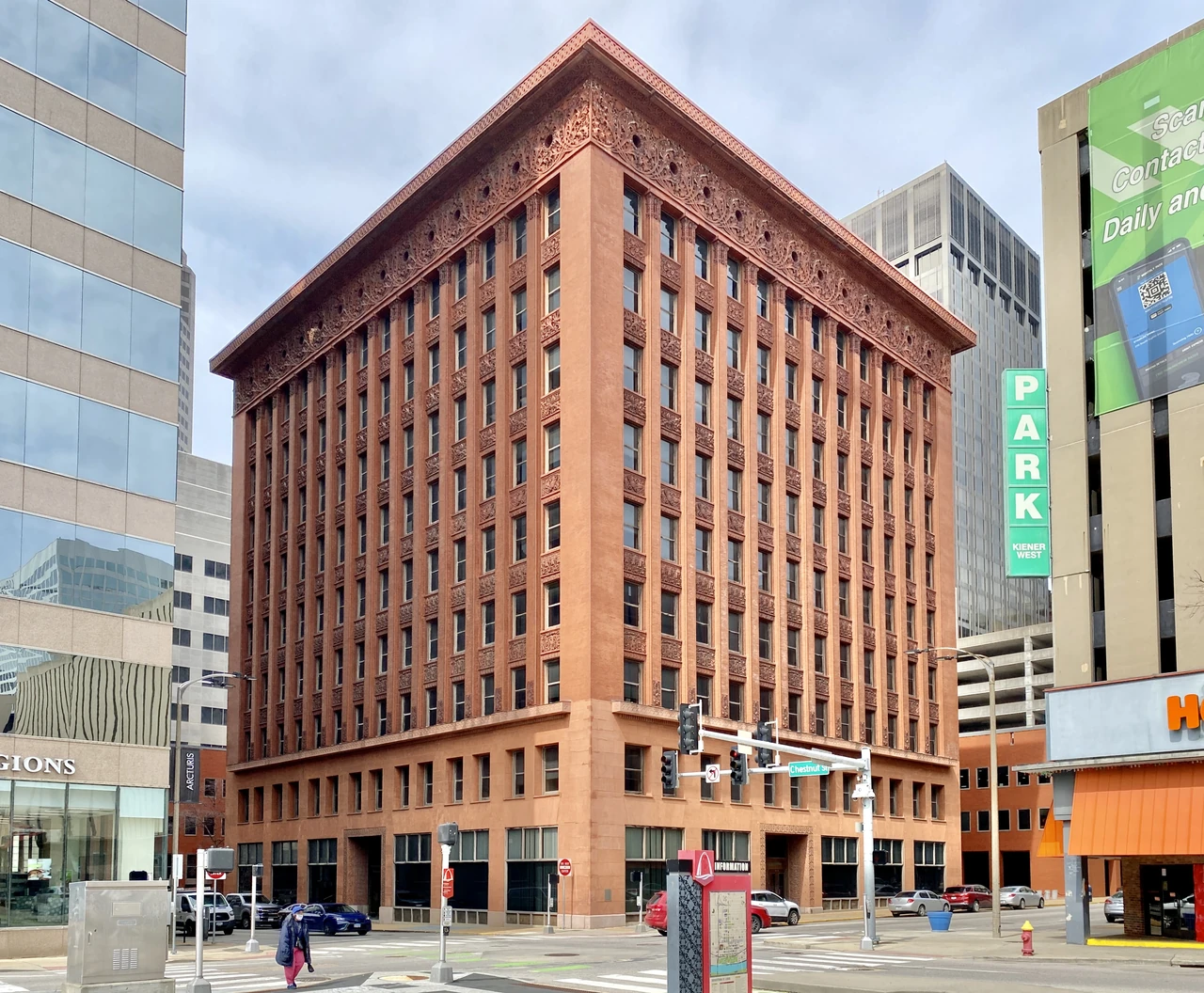 The Wainwright Building’s brick piers, repeated windows and richly ornamented upper band rise above its corner shopfronts.