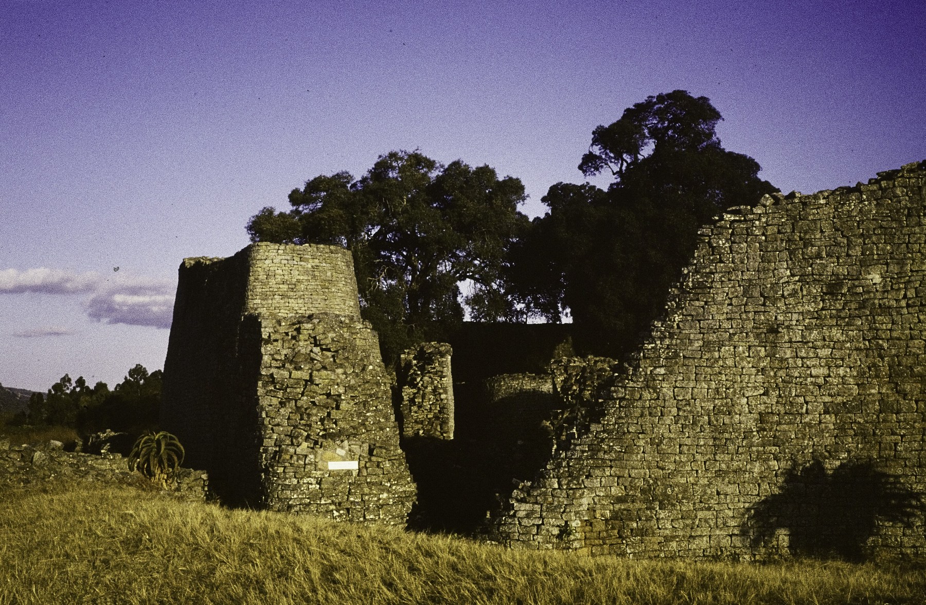 Great Zimbabwe granite enclosure walls and a tall conical stone form, photographed in 1975.