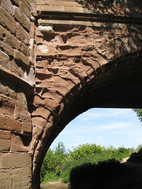 Weathered red sandstone voussoirs and joints at Wilton Bridge, with uneven loss of surface material.