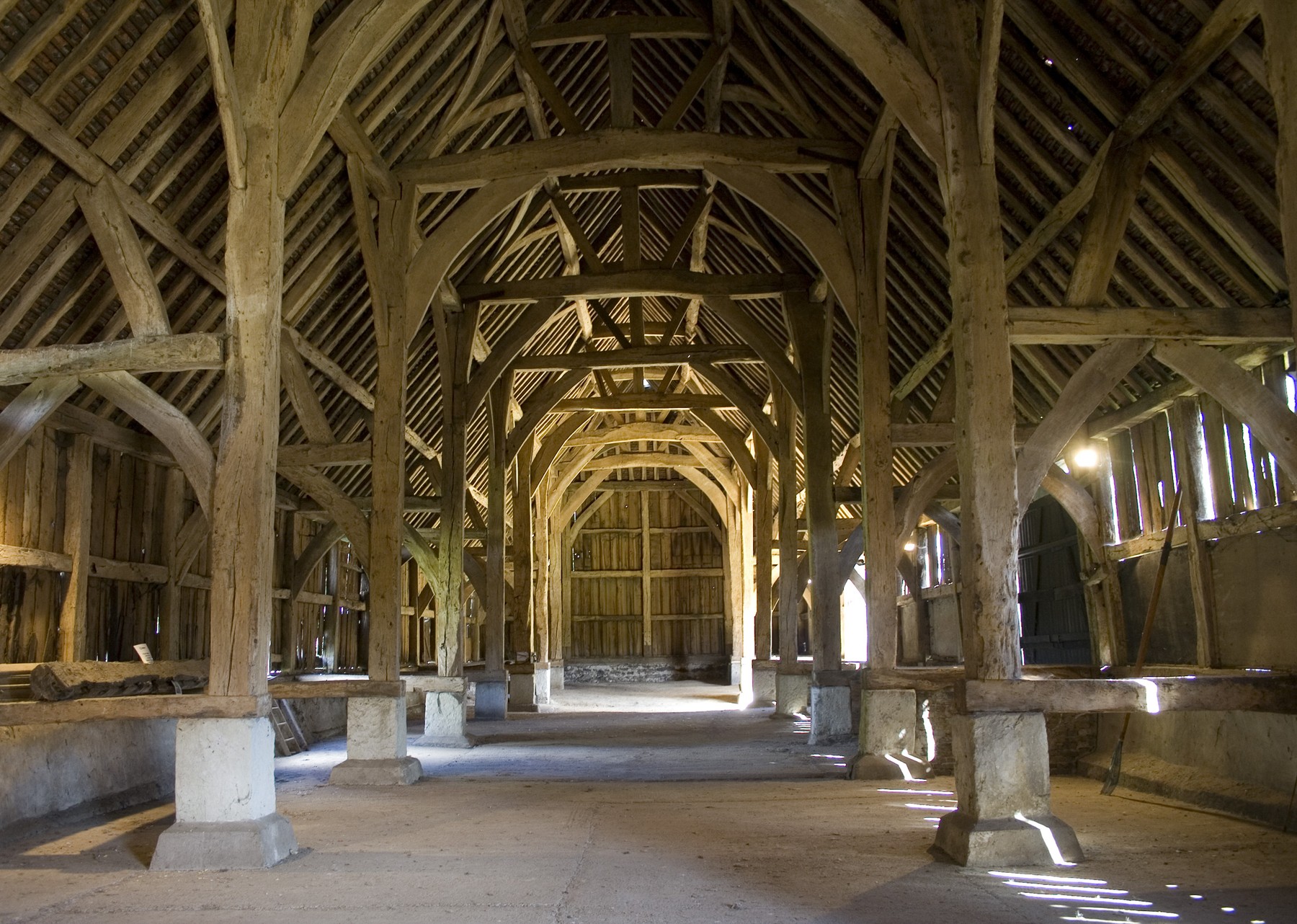 Rows of oak posts and curved braces inside Harmondsworth barn.