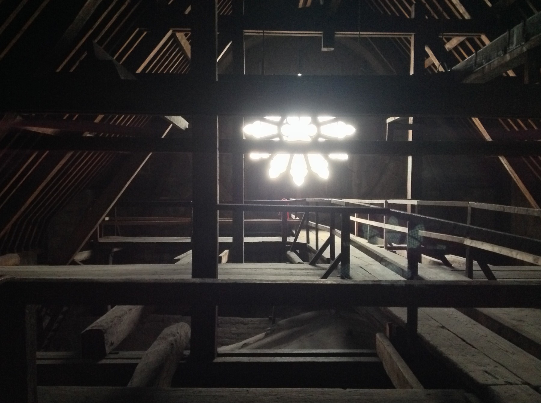 Dark timber members, a walkway and a gable window inside Notre-Dame's roof space before the 2019 fire.