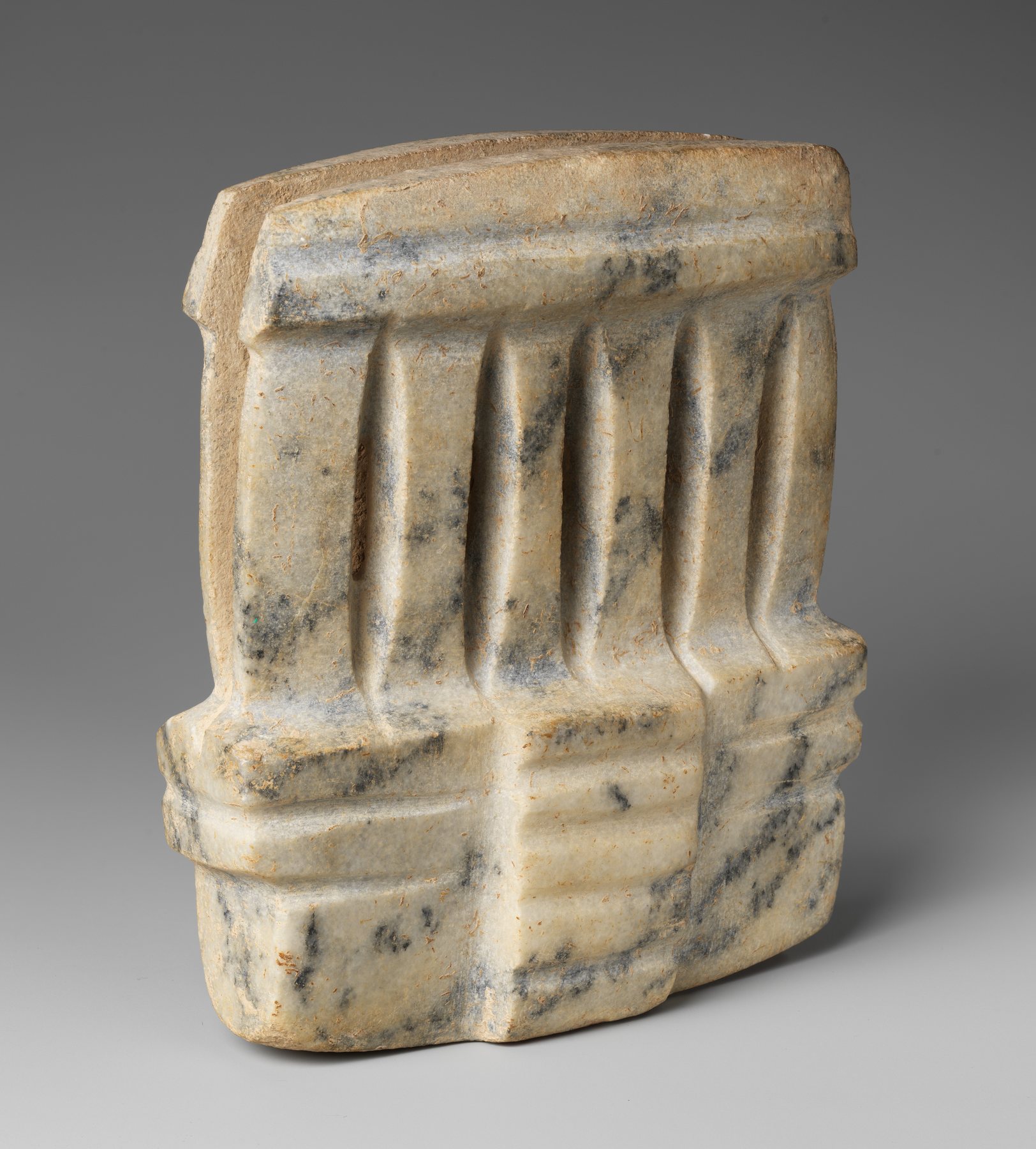 Small pale stone Mezcala architectural miniature with vertical grooves and stepped base.