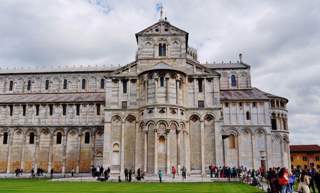 A rounded, arcaded apse projects from a gabled transept end, with lower side roofs and the long cathedral walls behind.