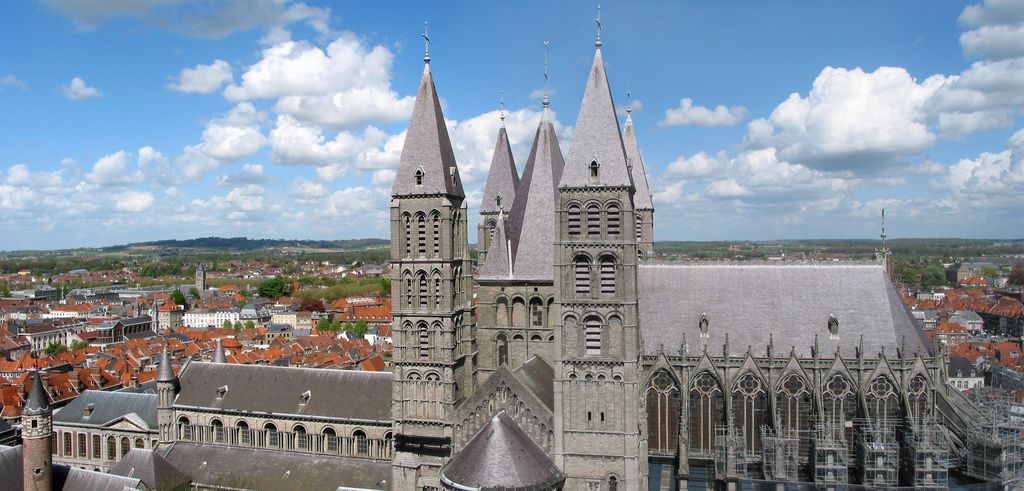 Five clustered tower roofs rise above the curved transept end between a lower arcaded nave at left and a tall windowed choir at right.