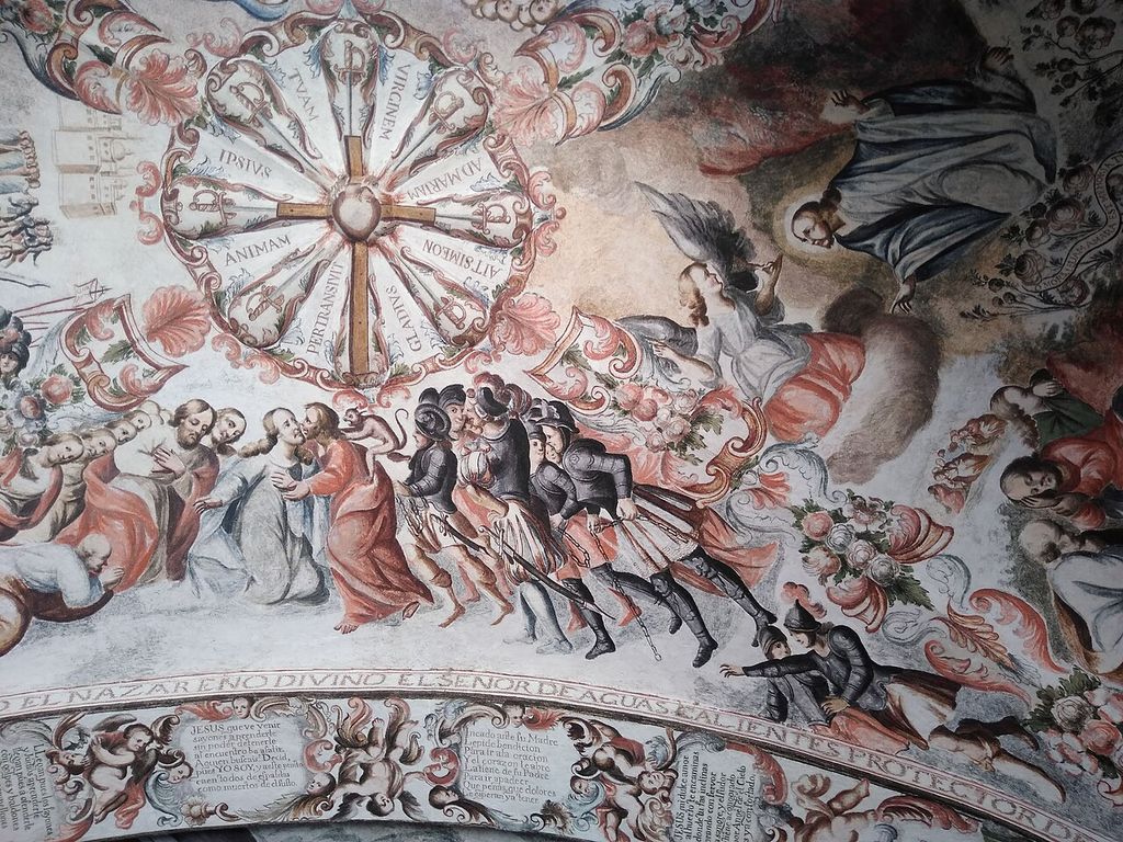 Painted religious figures and inscriptions arranged in decorative bands across a curved interior surface at Atotonilco.