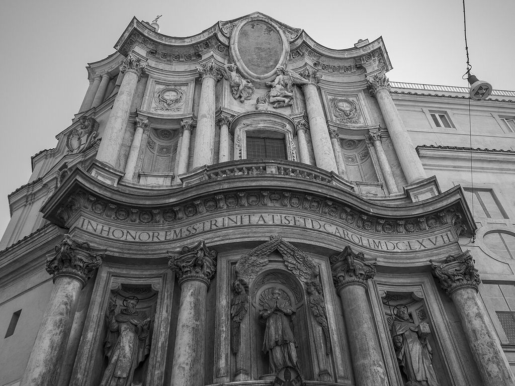 Monochrome upward view of San Carlo’s façade, with alternating curved bays, columns and projecting cornices.