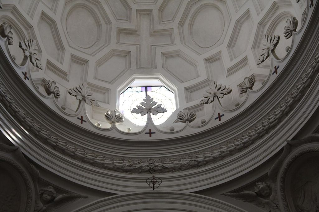 Cross-shaped and polygonal coffers above an ornamented curved cornice and window at San Carlo alle Quattro Fontane.
