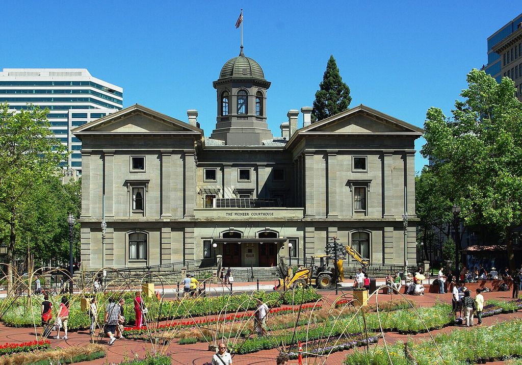 A central cupola and two pedimented wings overlook a busy planted plaza.