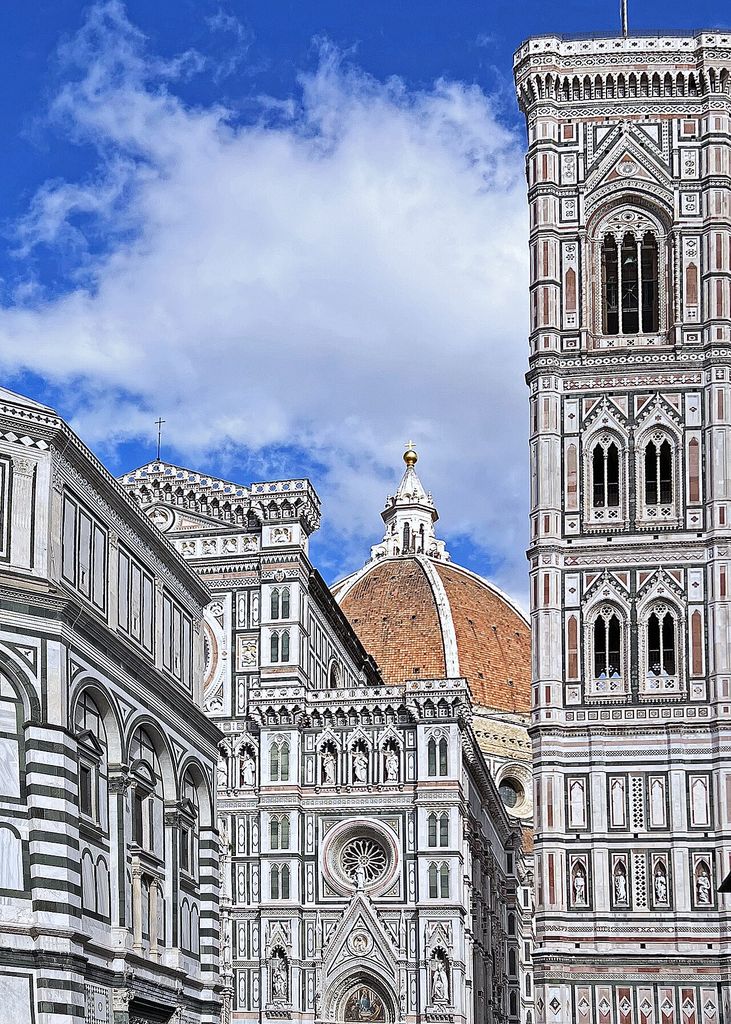 Terracotta dome rising behind Florence Cathedral’s patterned façade and tall marble-clad bell tower.