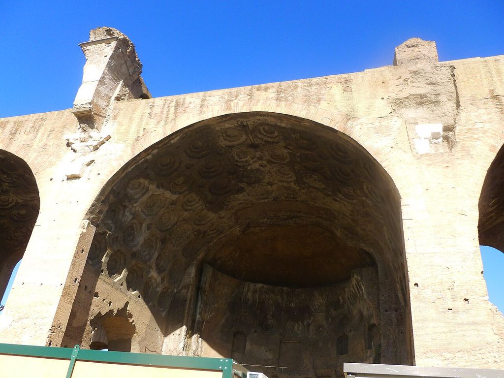 Broad arch opening beneath a deep coffered barrel vault in the ruined Basilica of Maxentius.