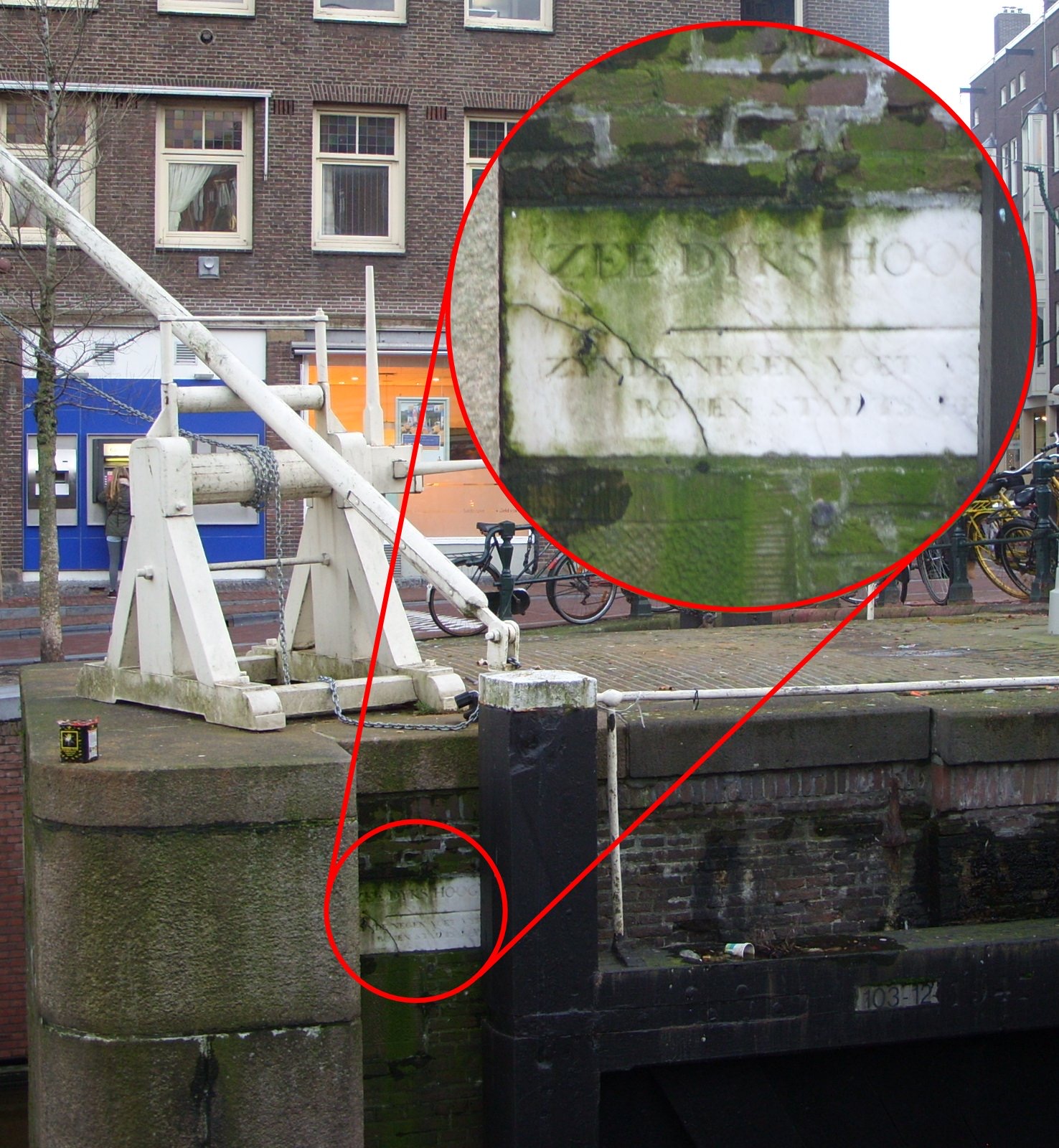 Amsterdam canal wall and sluice mechanism with red-outlined inset enlarging a worn Amsterdam Peil stone dated 1684.