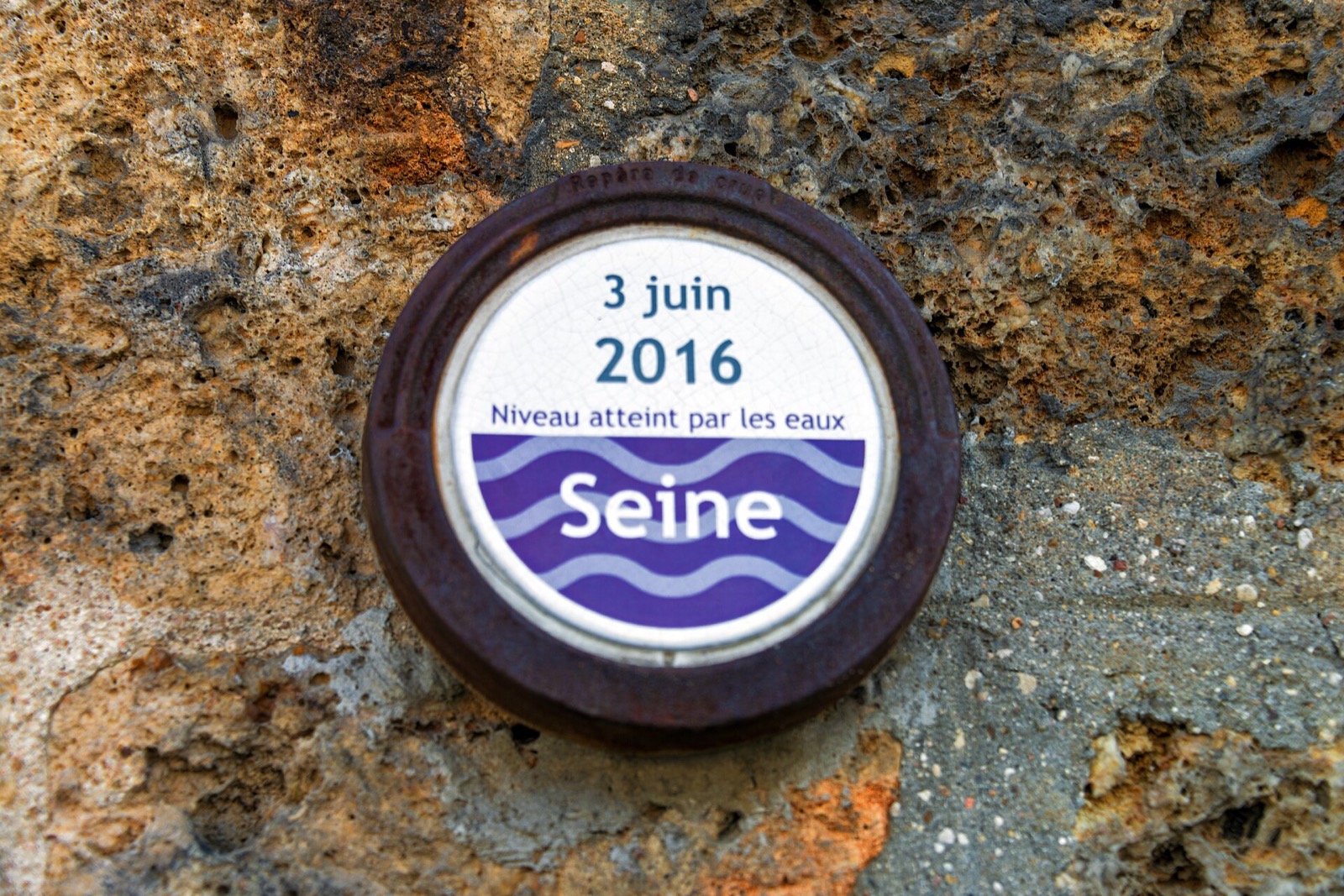 Round wall marker reading 3 June 2016 and indicating the flood level reached by the Seine.