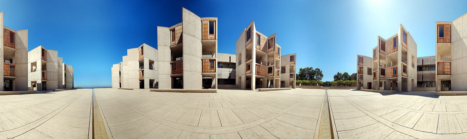 Wide panorama of Salk Institute court with paired concrete wings, central water channel and distant Pacific horizon.