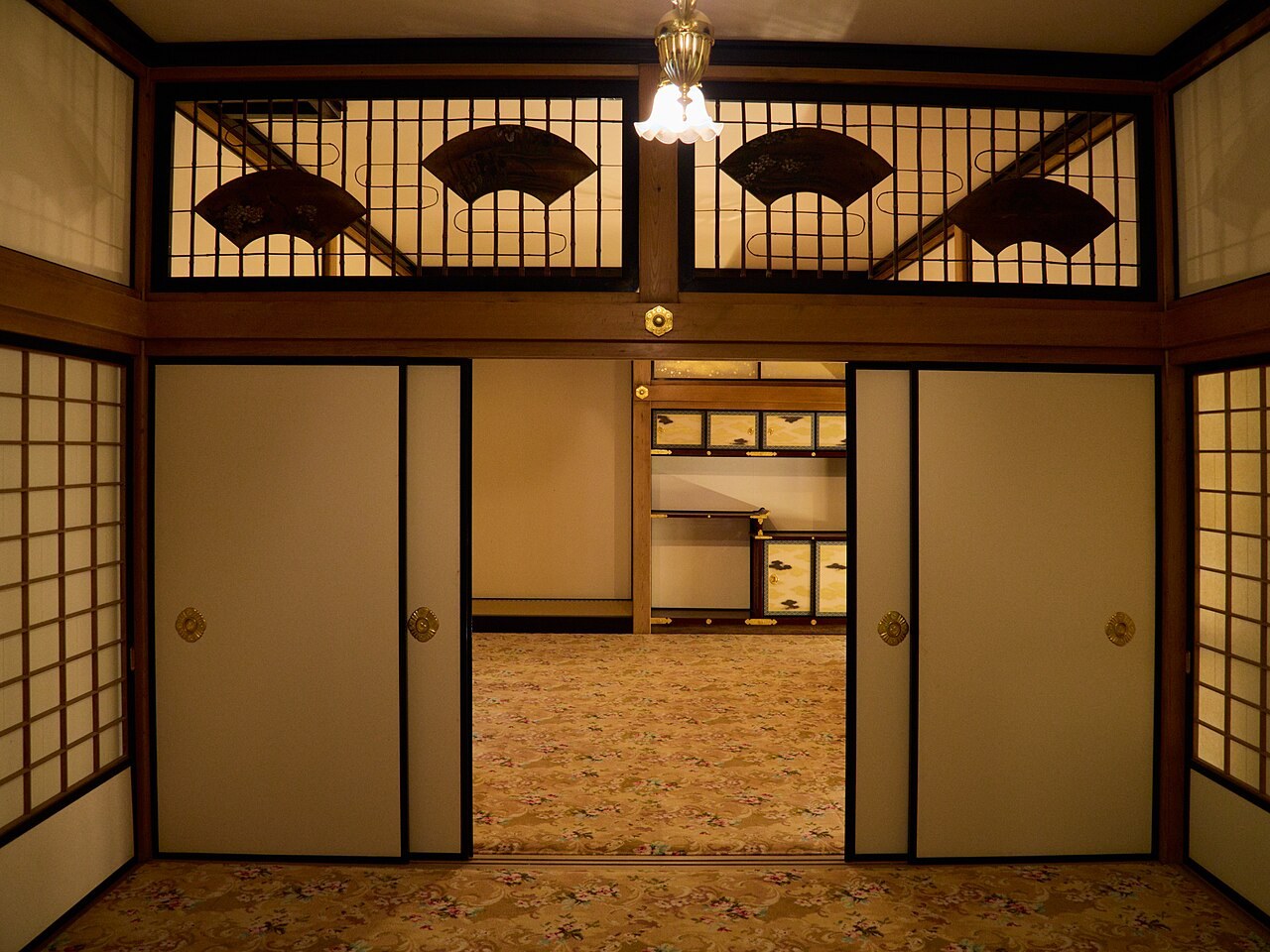 Japanese interior with sliding doors, paper screens and a lamp.