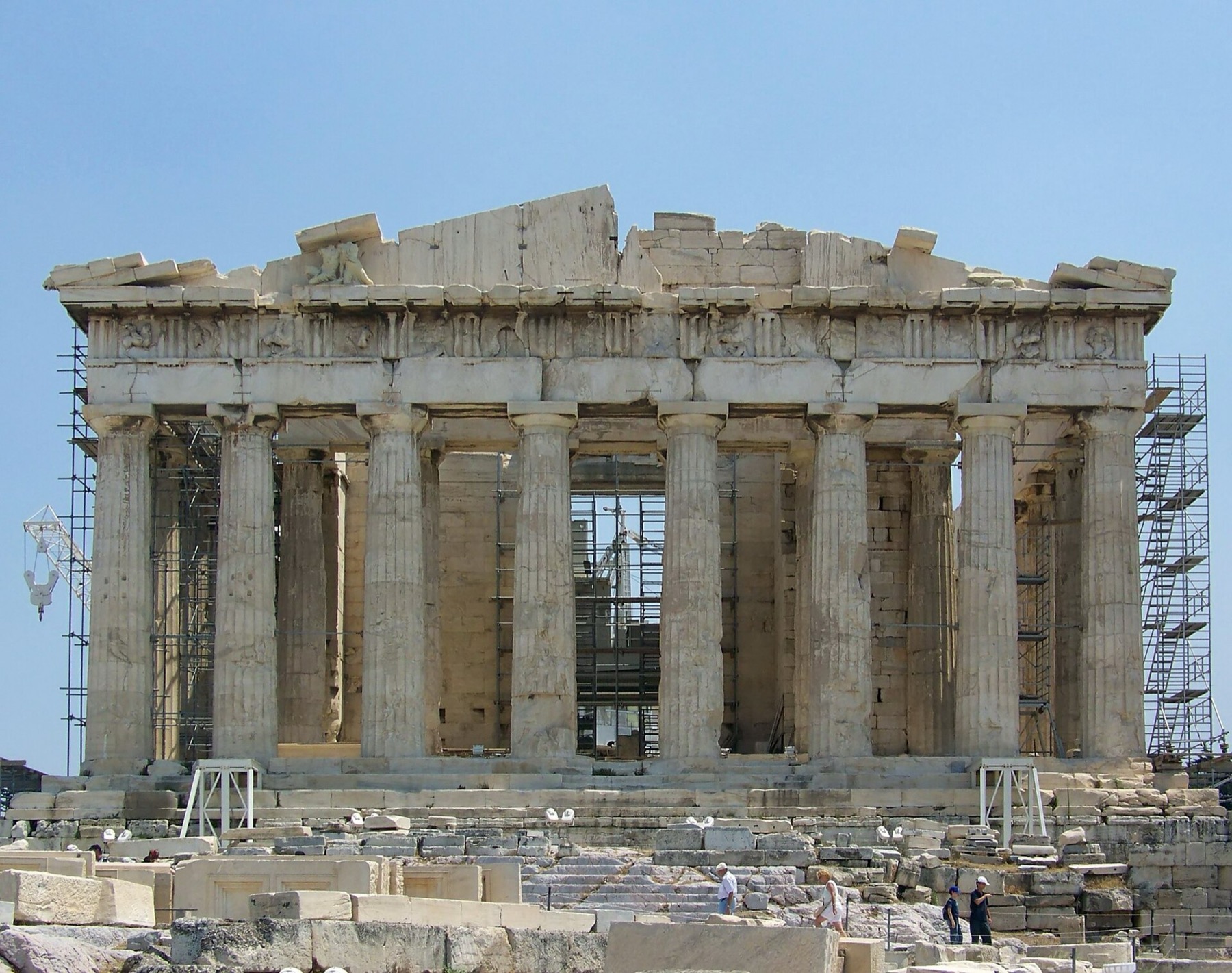 West front of the Parthenon during restoration, with columns, fragmentary pediment and scaffolding visible.