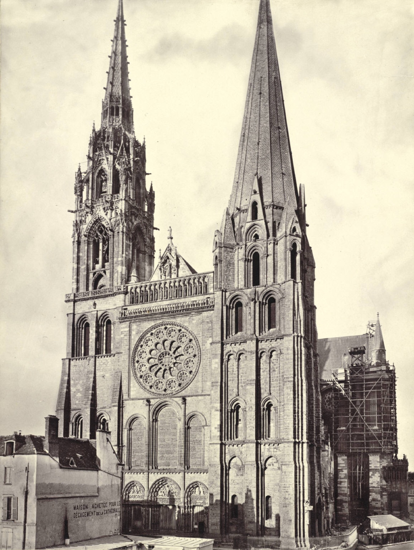 Historic black-and-white view of Chartres Cathedral west front with its unequal towers and rose window.