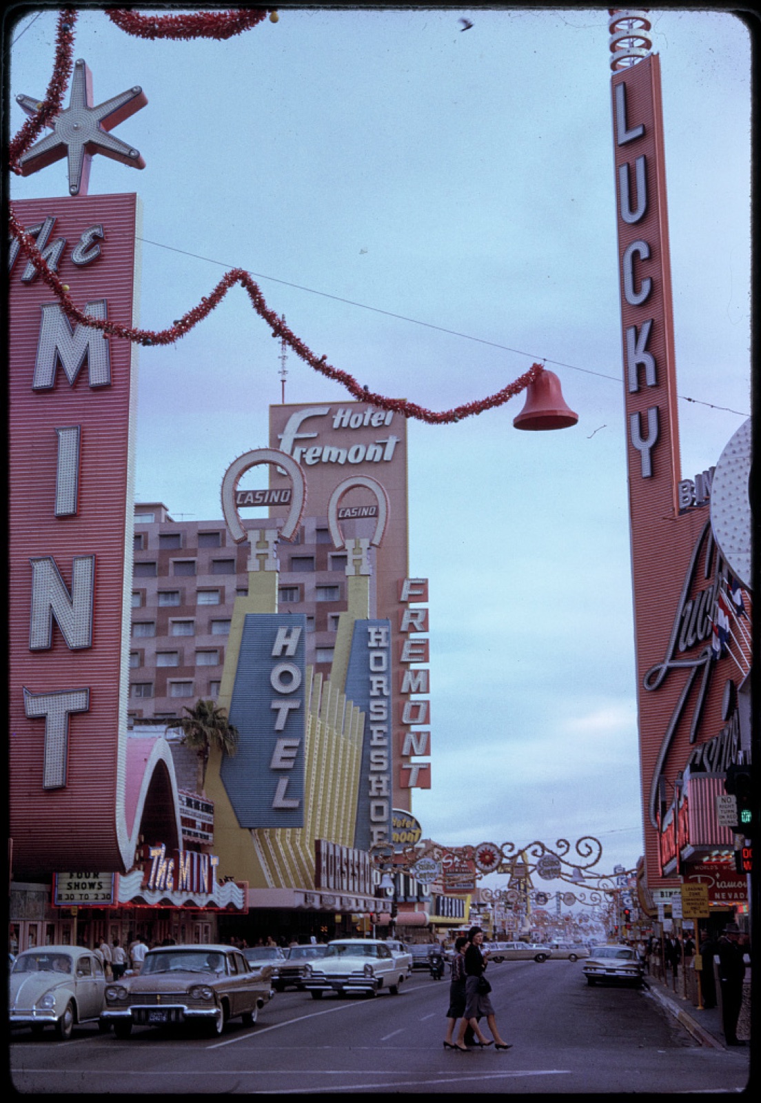 Bernard Gotfryd's January 1964 colour Las Vegas street slide with tall Mint, Fremont, Horseshoe and Lucky signs over traffic.