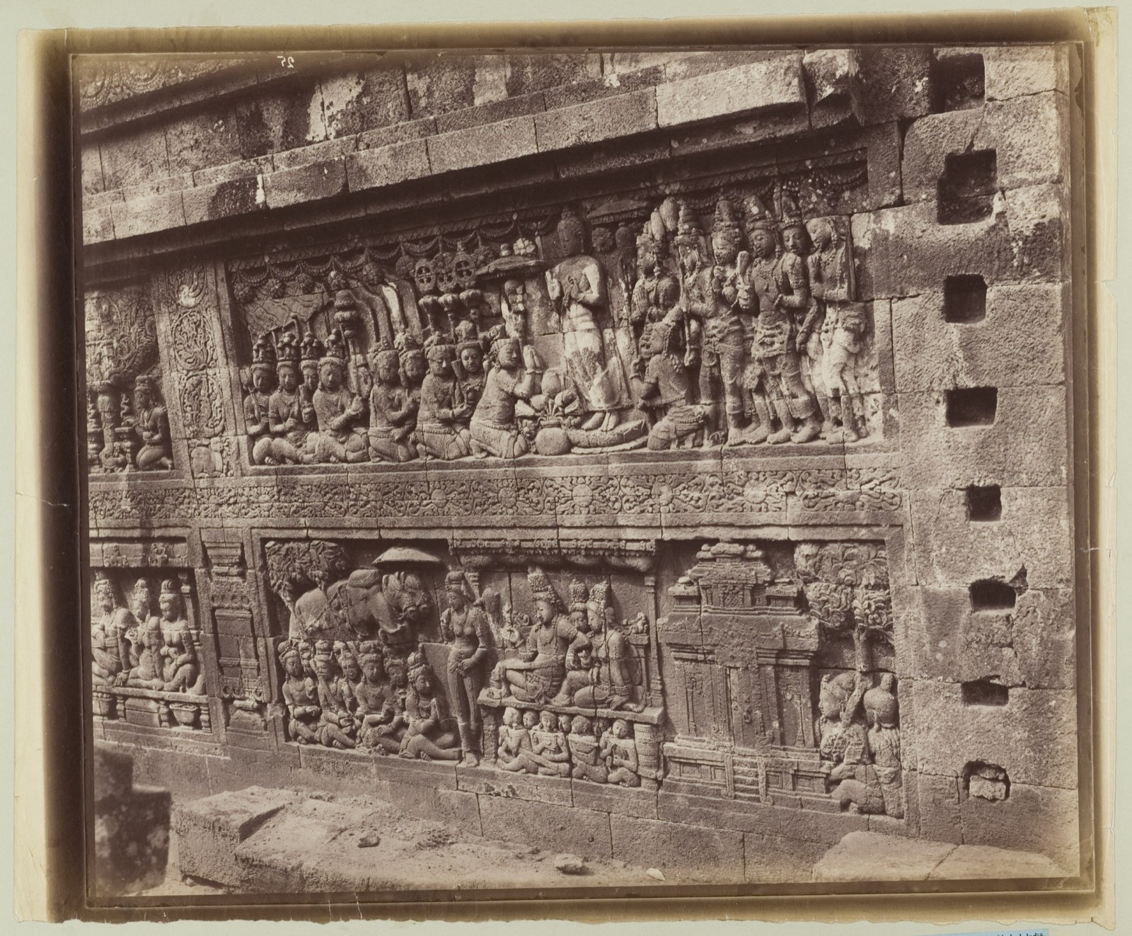 Historic sepia photograph of two adjacent Borobudur story relief frames with different figures.