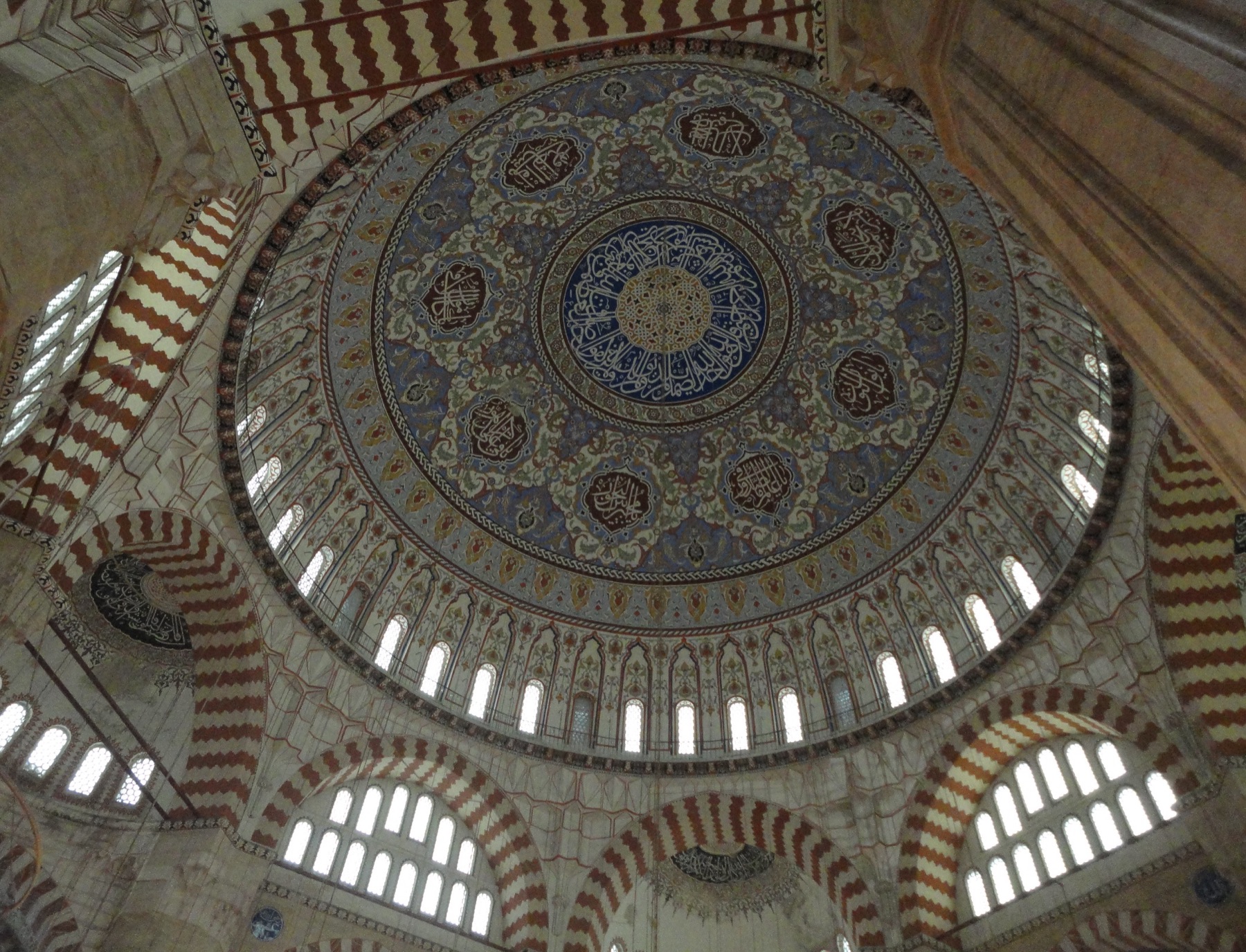 Interior photograph looking upward into ornamented dome and adjacent vaults at Selimiye Mosque in Edirne.