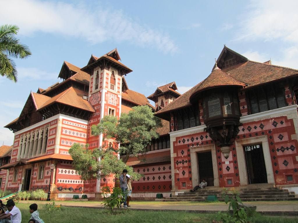 Overlapping tiled roofs and deep eaves rise above patterned walls, a projecting window bay and roofed towers.