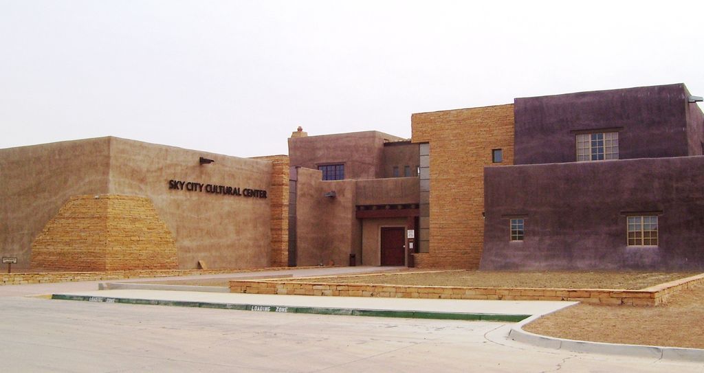 A contemporary cultural centre has stepped purple-brown and tan masses, low walls, stone-faced elements and a recessed entrance.