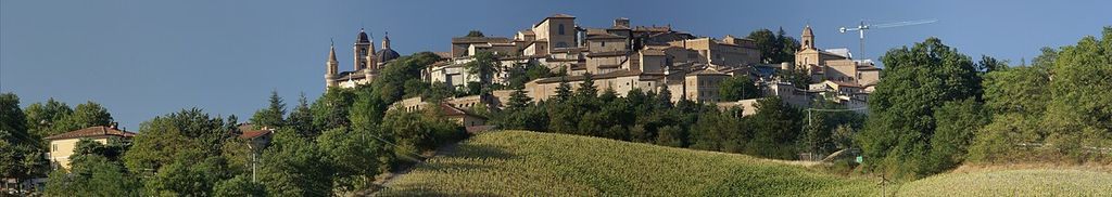 Panoramic view of the town of Urbino in Italy from a vantage point southeast of the city on a hill The two towers of the Palazzo Ducale (Ducal Palace) are visible to the left, the cupola and tower of the cathedral….