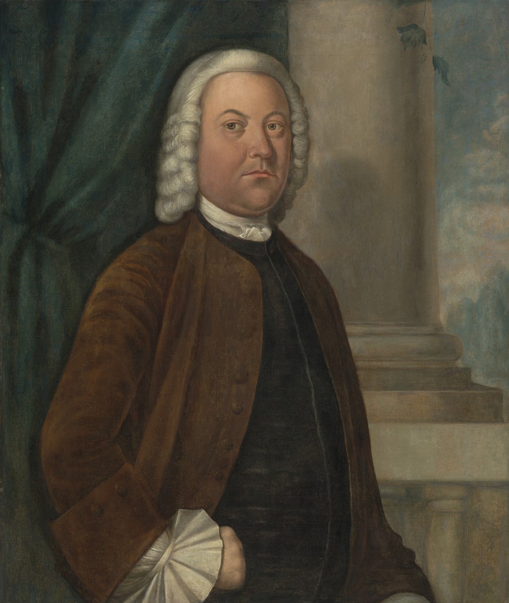 Samuel Boude in a pale wig and brown coat, with his hand at his hip, a green curtain behind him and a column to the right.