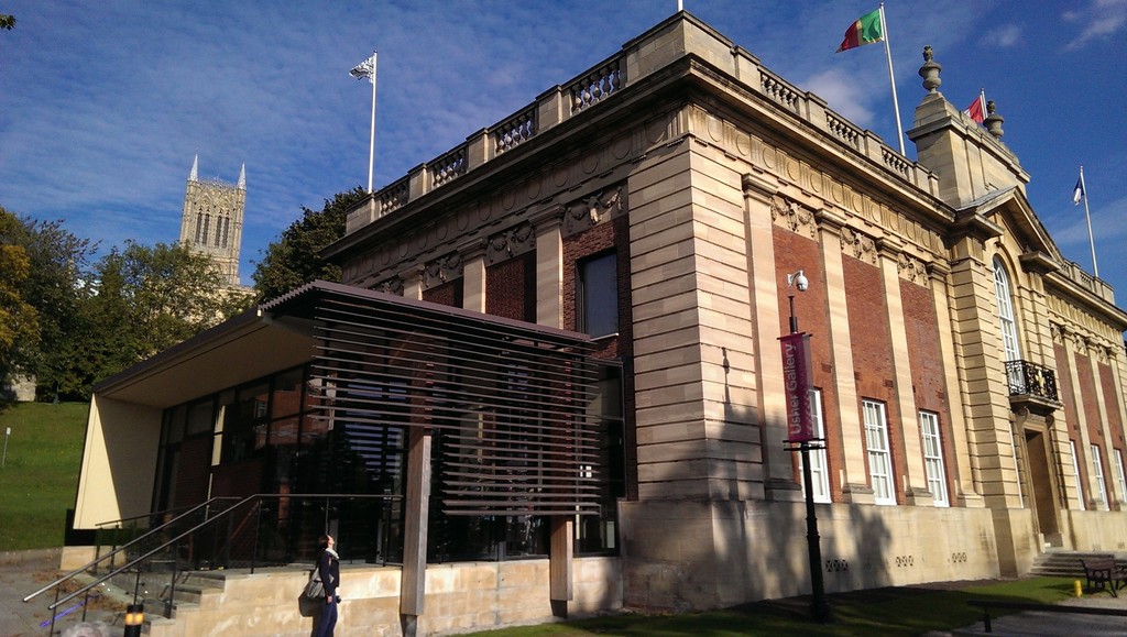 Usher Gallery, Lincoln, photographed by Duncan Verrall on 11 October 2015. Via Wikimedia Commons, CC BY 2.0; whole photograph, resized only. This modern exterior provides collection context, rather than depicting the acquisition or the painting’s position inside.