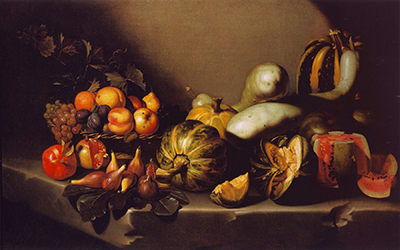 Fruit, figs, gourds and cut melon spread across a wide stone ledge against darkness.